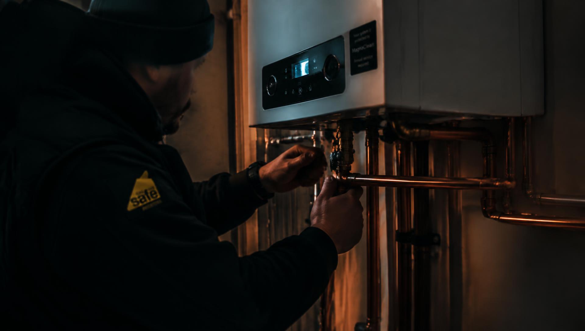 Gas Safe engineer fitting copper pipework to a boiler